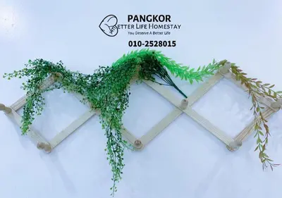 a wooden frame with green ivy on it at Better Life Apartment near beach-2room 2bathroom 6pax in Pangkor
