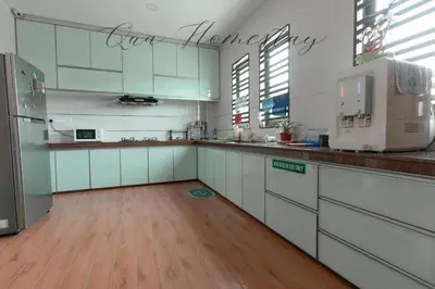 a kitchen with white cabinets and a counter top at Qua Homestay 5 Rooms 6 Bathrooms in Taiping