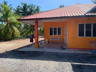 a small orange house with a red roof at D’baroh Homestay in Kampong Tanjong Karang