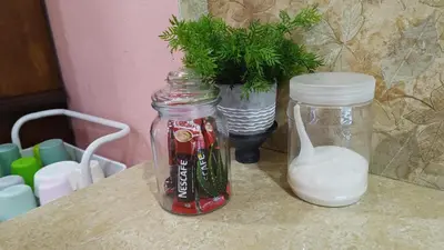 a table with two glass jars and a potted plant at Casa Indera in Kampung Bota Kiri