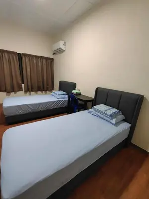 a room with two beds and a table with a chair at CLP perai homestay near Sri Muniswarar Temple 2 in Perai