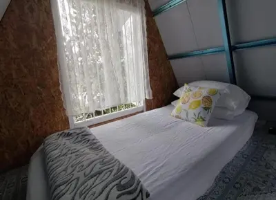 a small bed in a room with a window at D'RUMAH BONDA RIVER VIEW Kuala Kangsar in Kampong Senawar